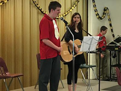 Student, Eli, performs solo with music therapist intern